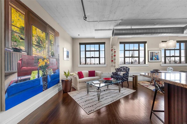 living room with dark wood-style flooring, rail lighting, and baseboards