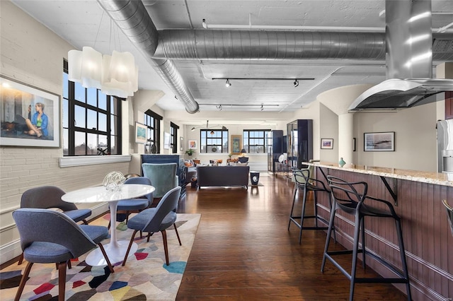 dining room featuring rail lighting and dark wood-style flooring