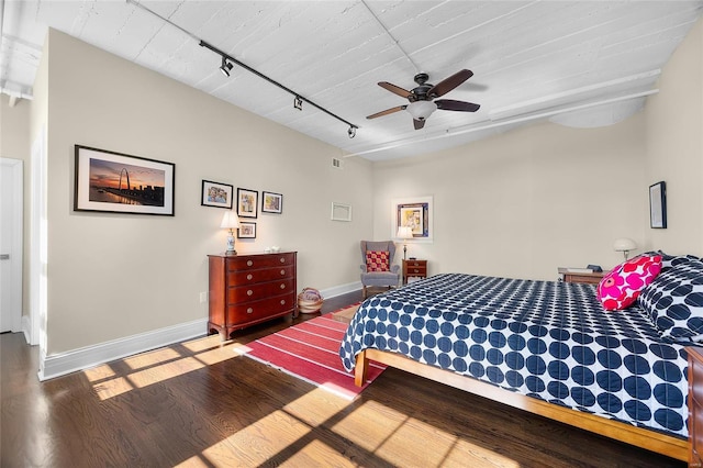 bedroom featuring track lighting, ceiling fan, baseboards, and wood finished floors