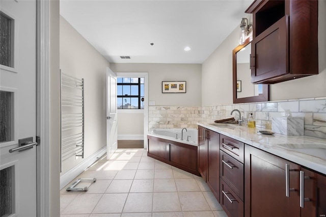 full bathroom featuring baseboards, radiator, tile patterned floors, vanity, and a bath