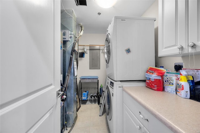 clothes washing area with stacked washer and dryer, laundry area, light tile patterned flooring, and electric panel