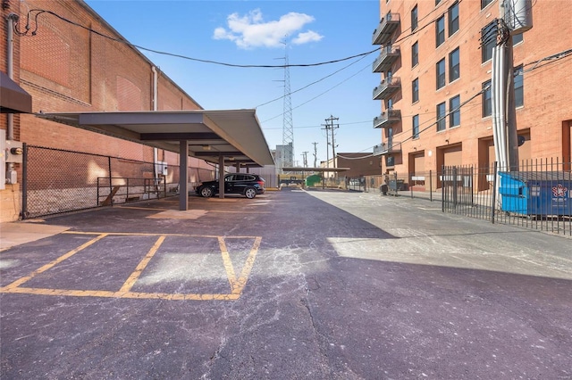 covered parking lot featuring fence