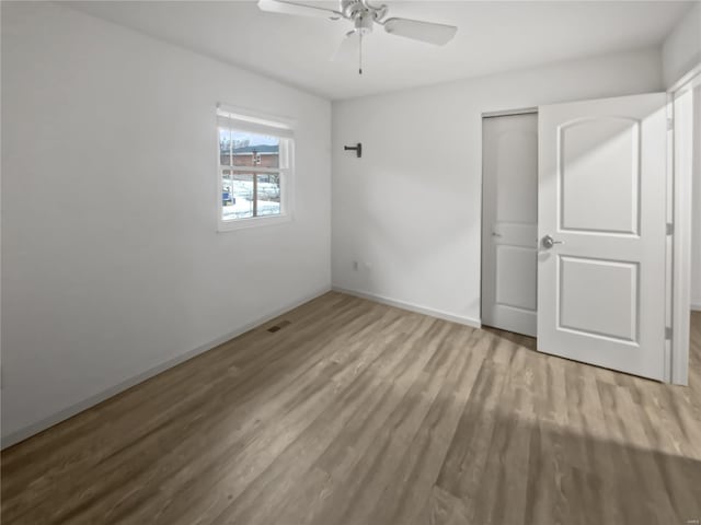 unfurnished bedroom with a ceiling fan, a closet, baseboards, and wood finished floors