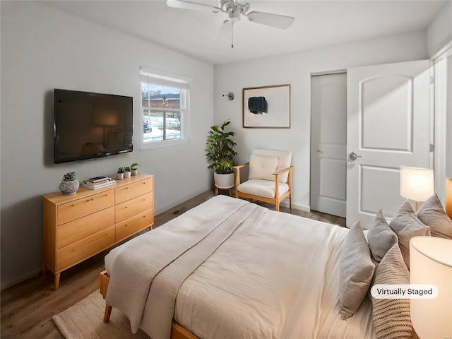 bedroom featuring ceiling fan, a closet, wood finished floors, and baseboards