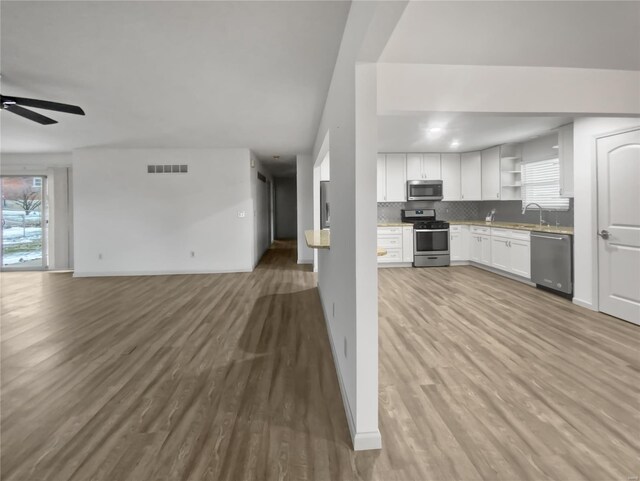 kitchen featuring open shelves, tasteful backsplash, visible vents, appliances with stainless steel finishes, and open floor plan