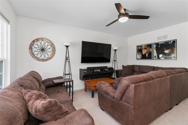 living room with light carpet, baseboards, visible vents, and a ceiling fan