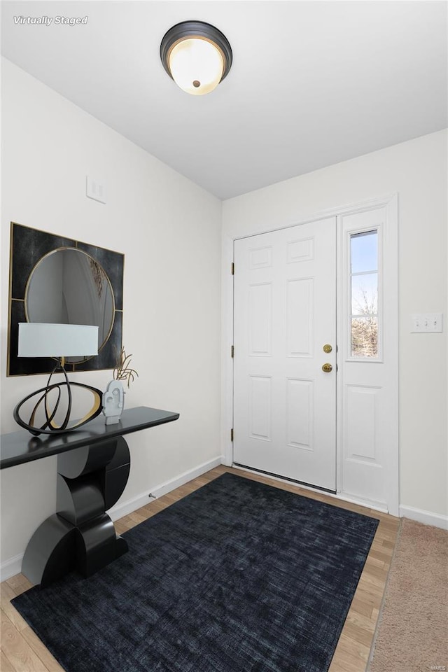 entryway with baseboards and wood finished floors