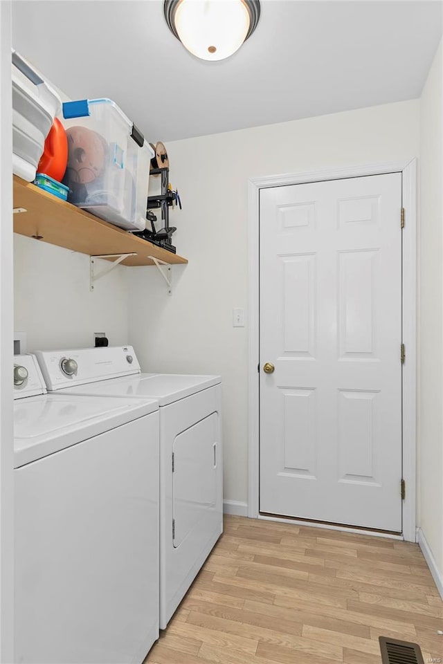 laundry room with laundry area, visible vents, baseboards, light wood-style floors, and washer and dryer