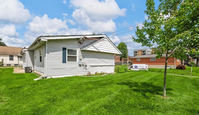 rear view of property with central AC and a yard