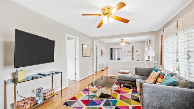 living area with ceiling fan, wood finished floors, and baseboards