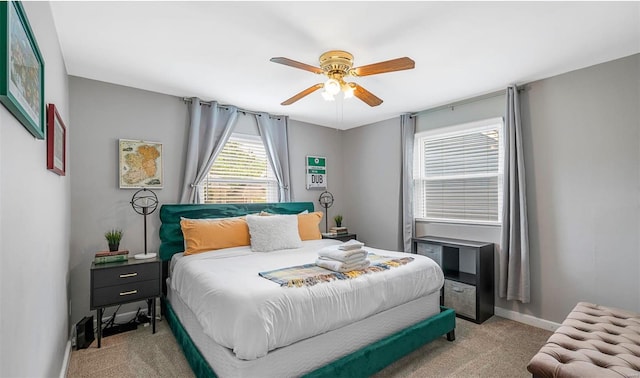 carpeted bedroom featuring baseboards and a ceiling fan