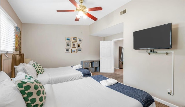 bedroom featuring ceiling fan, carpet, visible vents, and vaulted ceiling