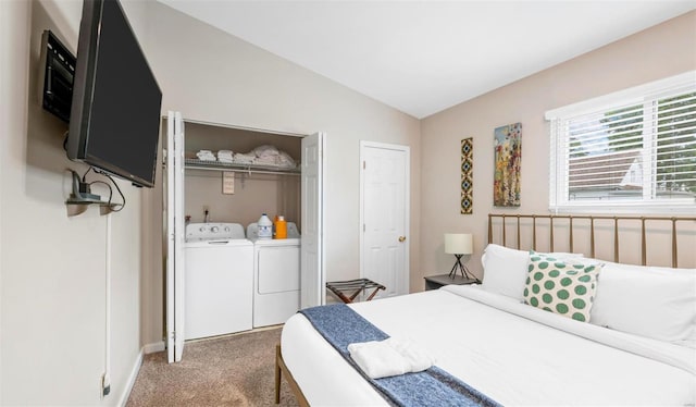 bedroom with vaulted ceiling, separate washer and dryer, and light carpet