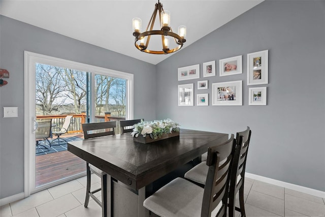 dining room featuring light tile patterned floors, baseboards, vaulted ceiling, and an inviting chandelier