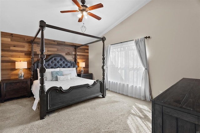 bedroom with lofted ceiling, light carpet, wood walls, and ceiling fan