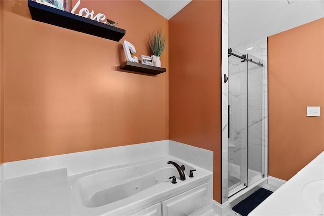 full bath featuring a tub with jets and a marble finish shower