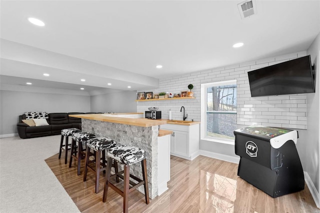 bar featuring a sink, visible vents, and recessed lighting