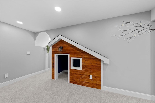 bonus room featuring baseboards, wood walls, carpet, and recessed lighting