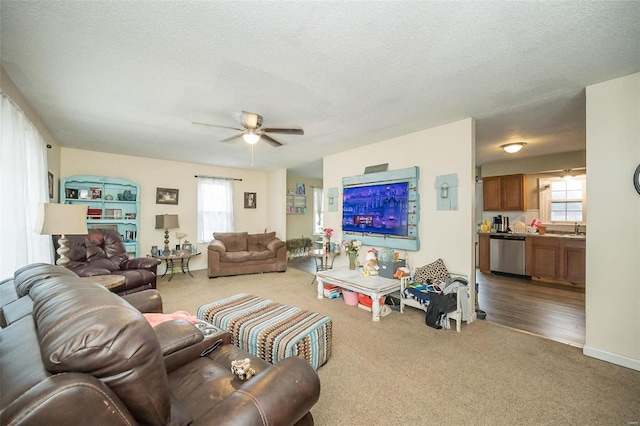 carpeted living room featuring a textured ceiling, a sink, and a ceiling fan