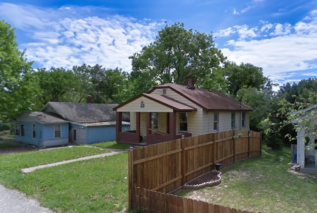 bungalow with fence and a front lawn