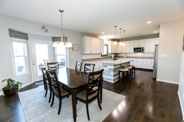 dining area with baseboards, dark wood-type flooring, and recessed lighting