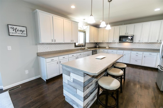 kitchen featuring stainless steel appliances, white cabinets, visible vents, and a sink