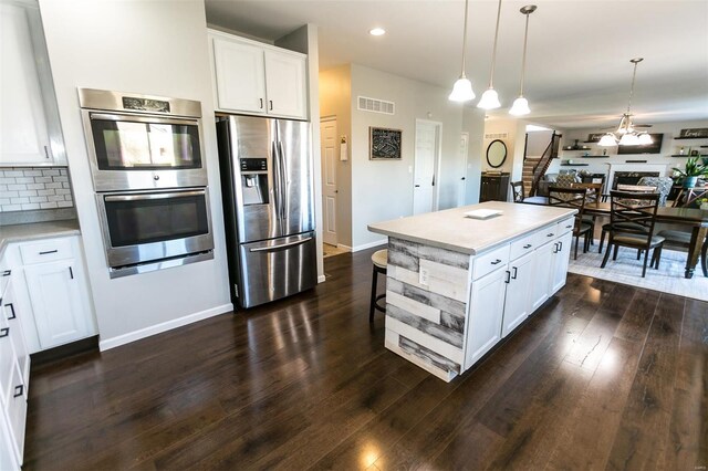 kitchen with stainless steel appliances, light countertops, visible vents, dark wood-type flooring, and white cabinetry