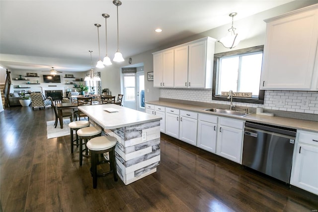 kitchen with dishwasher, dark wood-style floors, a sink, and decorative backsplash