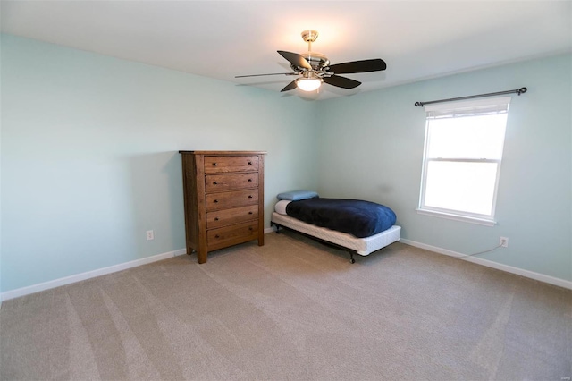 bedroom with light carpet, ceiling fan, and baseboards