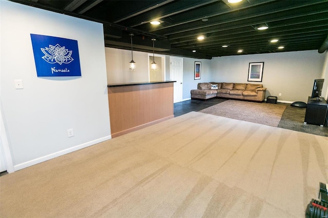 living area featuring dark carpet and baseboards