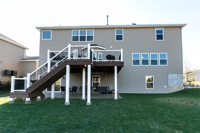 rear view of property featuring stairs, a patio, a yard, and a wooden deck