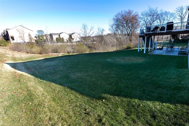 view of yard featuring a patio area and a wooden deck