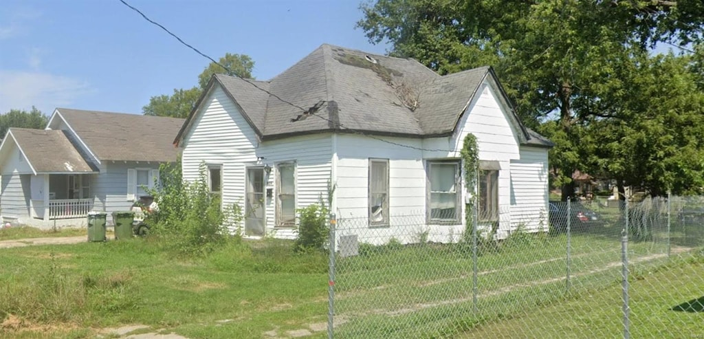 view of property exterior with a yard, a shingled roof, and fence