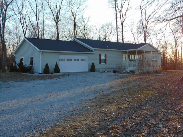 single story home featuring gravel driveway and an attached garage