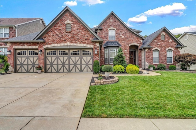 view of front of property featuring concrete driveway, a front yard, a shingled roof, a garage, and brick siding