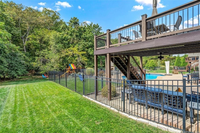 view of yard featuring a patio, stairway, fence, a fenced in pool, and a playground