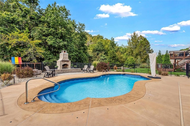 view of swimming pool featuring a fenced in pool, a patio, an outdoor stone fireplace, and fence