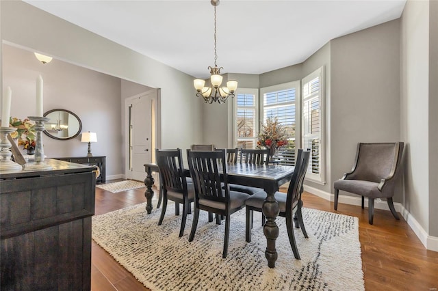 dining room featuring baseboards, a notable chandelier, and dark wood finished floors