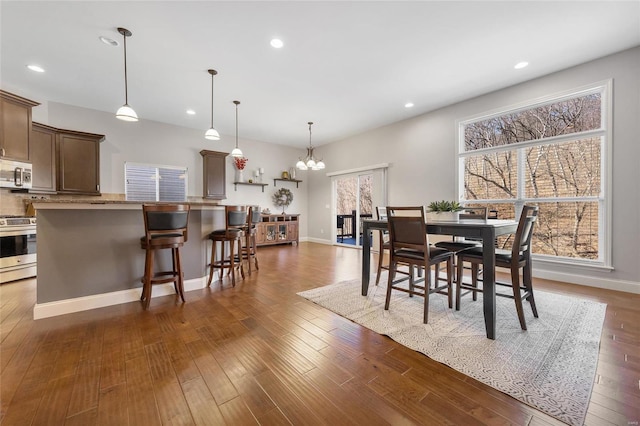 dining room featuring dark wood-style floors, recessed lighting, an inviting chandelier, and baseboards