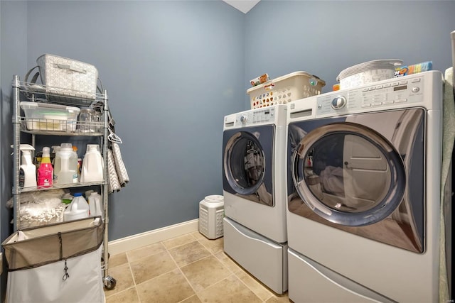 washroom with light tile patterned floors, laundry area, baseboards, and separate washer and dryer