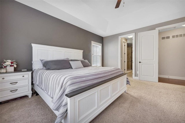 bedroom featuring baseboards, light colored carpet, and a ceiling fan