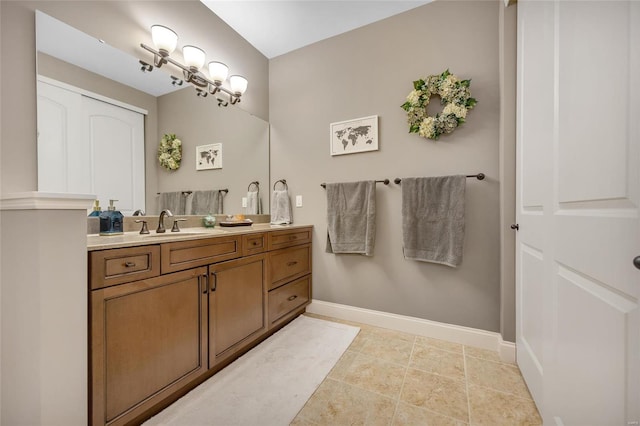 bathroom featuring an inviting chandelier, vanity, and baseboards