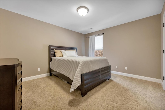 bedroom with baseboards and light colored carpet