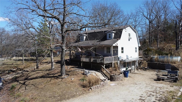 rear view of property with a shingled roof, stairway, a wooden deck, and a gambrel roof