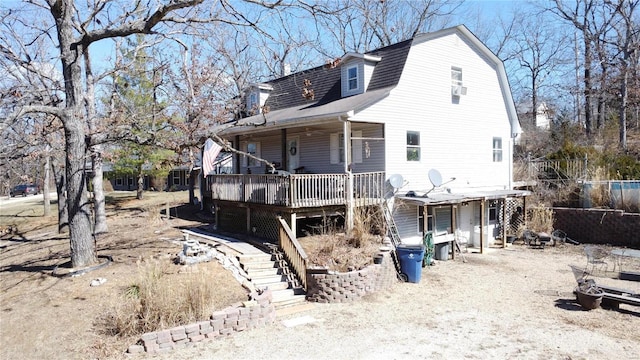 rear view of property featuring roof with shingles, stairway, a wooden deck, and a gambrel roof