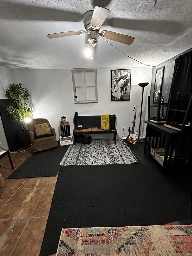 living area with a textured ceiling and ceiling fan