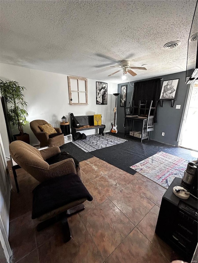 living area featuring a textured ceiling, visible vents, and a ceiling fan