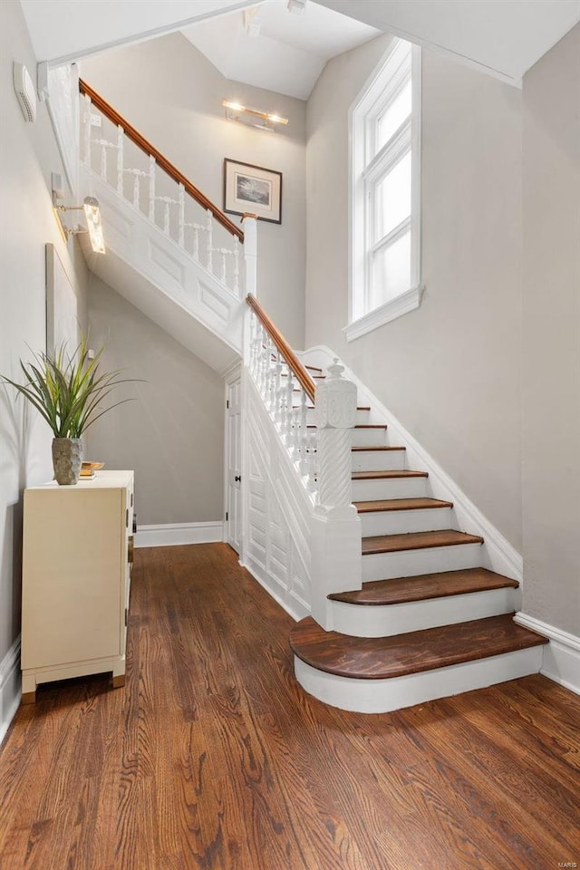 stairway with baseboards and wood finished floors