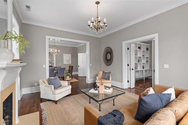 living room featuring a chandelier, visible vents, a fireplace with flush hearth, and wood finished floors