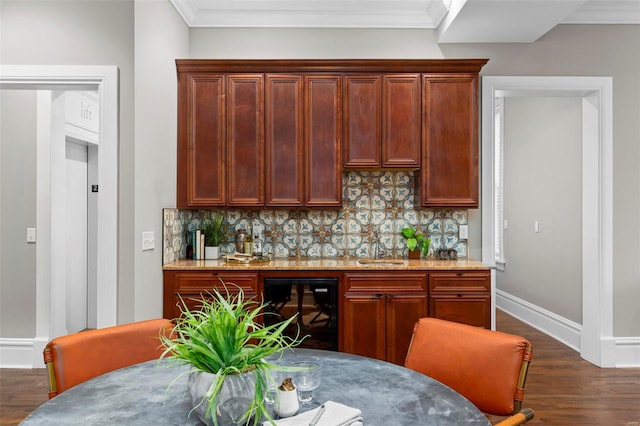 kitchen featuring tasteful backsplash, crown molding, and dark wood-type flooring